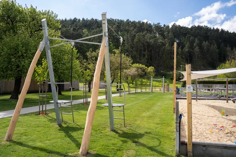 Detská lanová dráha s drevenými stĺpmi na tráve vo Villa Betula Resort.