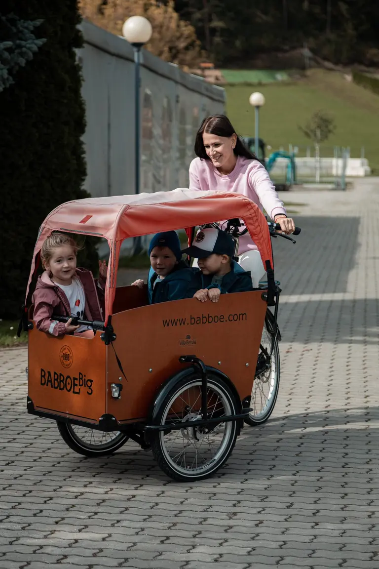 Mama vezie deti na rodinnom e-bicykli