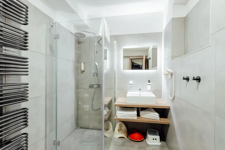 Moderná kúpeľňa so sprchou, umývadlom a detským vybavením vo Villa Betula Resort.