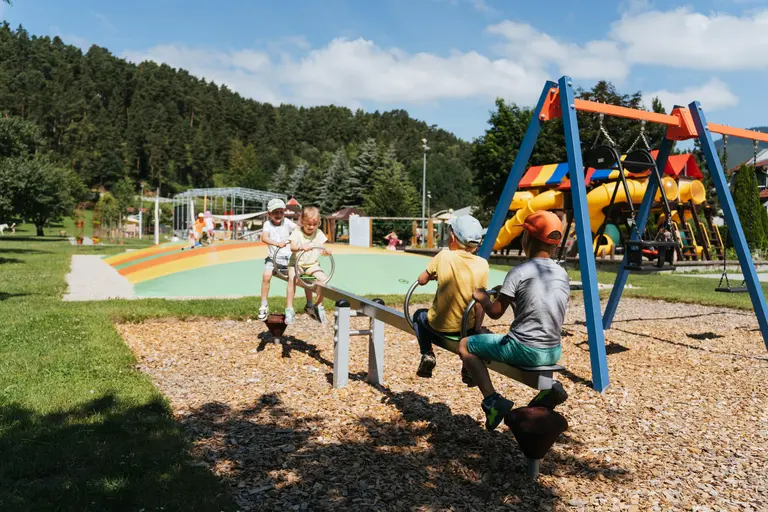 Deti sa hrajú na hojdačke na ihrisku Babyland vo Villa Betula Resort.