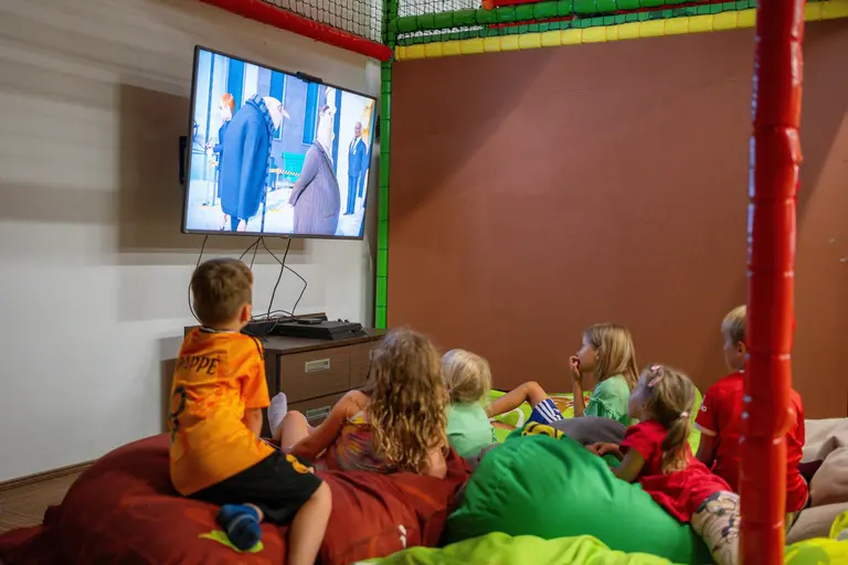 Deti sledujú animovaný film na TV vo Villa Betula Resort.