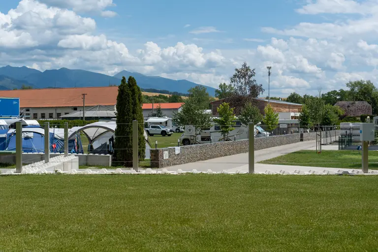 Kemping Villa Betula s karavanmi, stanmi a horami v pozadí.