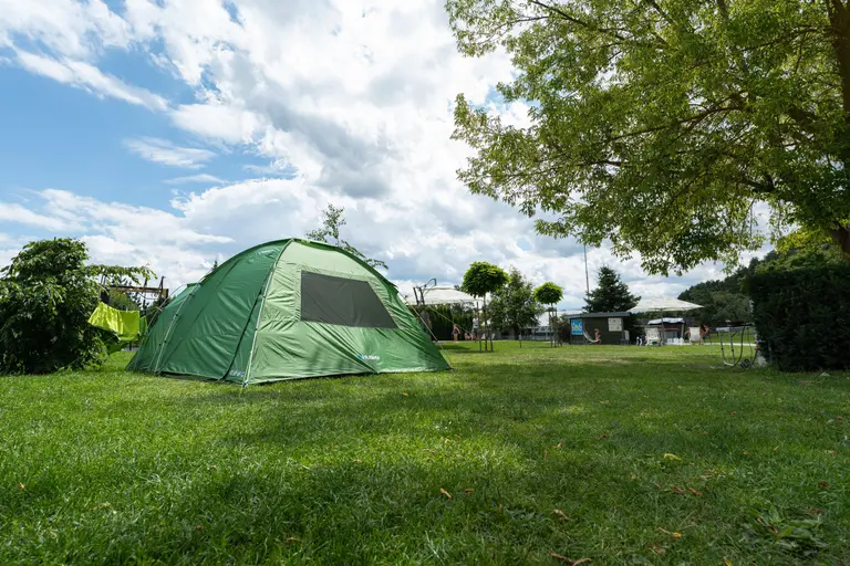 Zelený kempingový stan na tráve vo Villa Betula Resort.