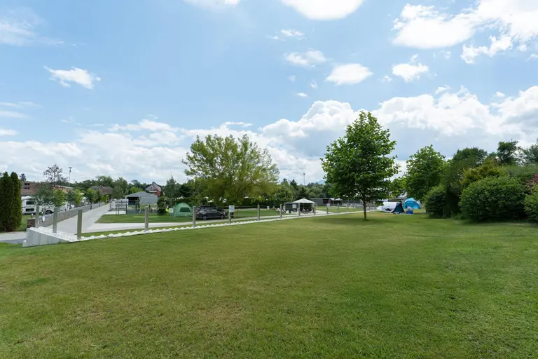 Zelená trávnatá plocha a kempingové parcely vo Villa Betula Resort.
