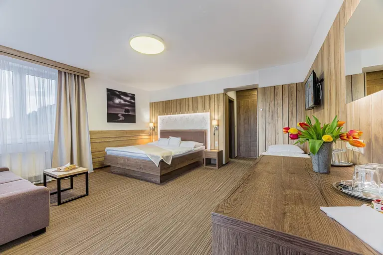 Priestranná moderná spálňa s manželskou posteľou vo Villa Betula Resort.
