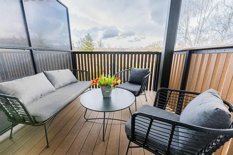 Terasa s moderným posedením a kvetmi vo Villa Betula Resort.