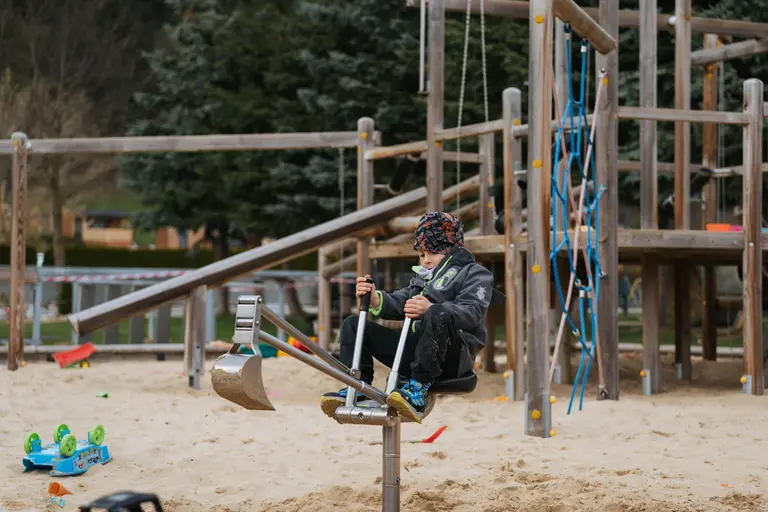 Chlapec ovláda rýpadlo na pieskovisku v detskom areáli Villa Betula.